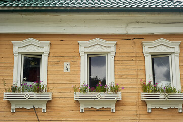 Old wooden houses with beautiful windows.Frames with tiles.An old Russian house.