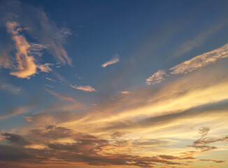 Colorful cloudy sky at sunset. The sun shines on the clouds. Color gradient. Sky texture. Abstract natural background.