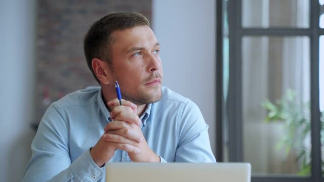 Serious man student sit at home office desk with laptop thinking of inspiration search problem solution ideas lost in thoughts.