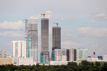 Fototapeta na wymiar View to the high-rise buildings under construction in summer city