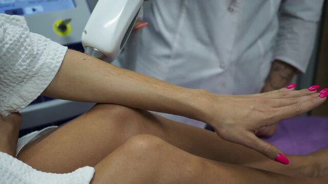 woman works with a laser hair removal on the hand