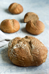 Homemade whole grain wheat and rye bread with buns on the background