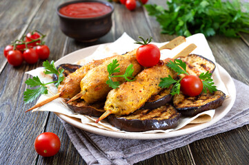 Lula kebab with grilled eggplant on pita bread. Dietary chicken kebabs on a skewer with vegetables.