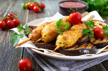 Lula kebab with grilled eggplant on pita bread. Dietary chicken kebabs on a skewer with vegetables.