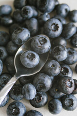 Fresh ripe blueberry on spoon. Dark background of sweet black berries