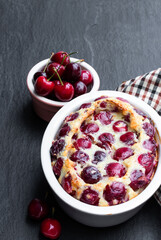 Clafouti cherry pie on black stone background