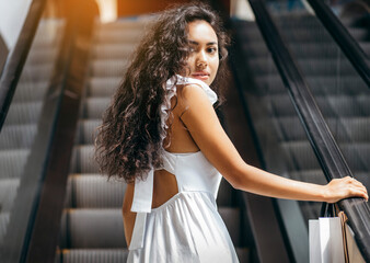 Young woman with bags on escalator