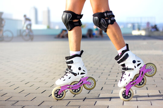 Close-up of woman's legs with inline skates doing roller skating tricks outside. Summertime sport activity concept.