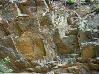 Rock in light brown and grey colors. Natural cracks and layers usable for texture or background.