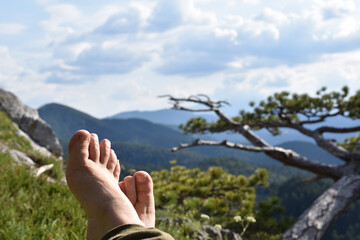 Urlaub in der Nähe, daheim Ferien machen, Hügellandschaft für Outdooraktivitäten, Füße beim Entspannen barfuß ausgestreckt