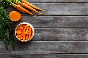 Sliced carrot and juice on wooden table top view copy space