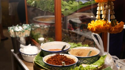 Bowls with traditional Asian sauces. Bowls with various traditional oriental sauces placed on stall in street food court in Thailand.