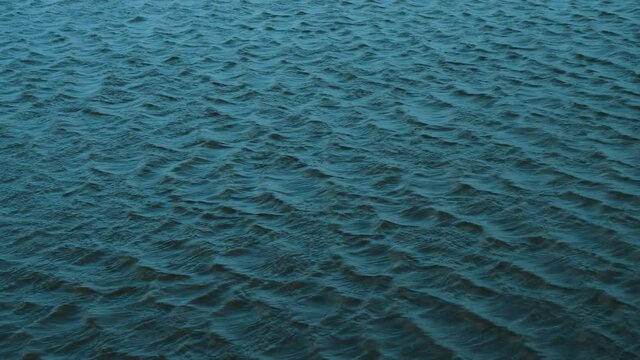 Dark blue ocean sea water, waves ripples in slow motion. Water texture background footage, cold color tonality