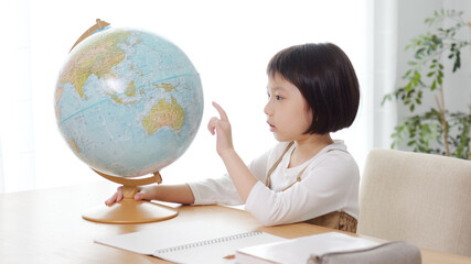 地球儀を見て勉強する子供