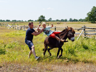 boy riding a donkey in the village