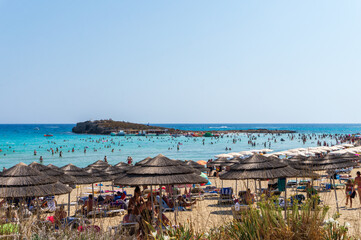 Obraz premium Ayia Napa - AUGUST 13, 2019 : Tourists at Nissi bay beach relaxing and enjoying their summer holidays at Ayia Napa area in Cyprus