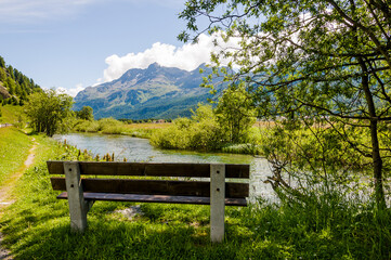 Fototapeta premium Sils, Segl, Sils-Maria, Baselgia, Oberengadin, Inn, Fluss, Holzbank, Surlej, Corvatsch, Furtschellas, Wanderweg, Oberengadin, Engadin, Graubünden, Alpen, Sommer, Schweiz