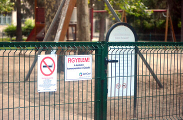 entrance of an outdoor children's playground with warning signs in Hungary.