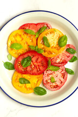 salad of red and yellow tomatoes and basil
