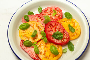 salad of red and yellow tomatoes and basil close-up
