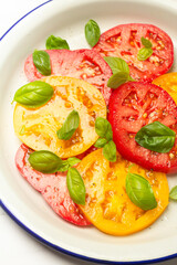 salad of tomatoes and basil on a plate close-up
