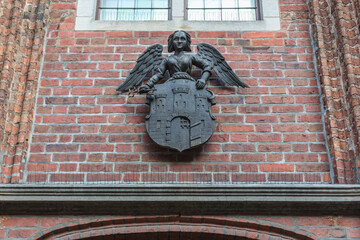 Coat of arms on a Old Town City Hall building on the main square of historic part of Torun city in north central Poland © Fotokon