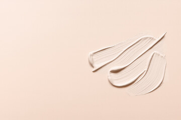 Liquid foundation strokes on nude color background. Makeup creamy texture. Skin tone cosmetic product smear smudge swatch