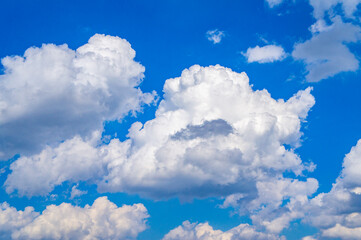 Naklejka na ściany i meble White bright contrasting clouds on blue sky