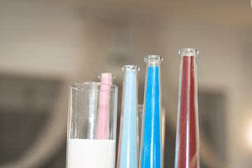 Stylish decorative glass colored vases for fresh flowers decorating the festive table.