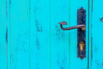 A blue wooden door with rough handle.