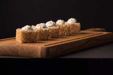 Sushi rolls with sesame seeds on a wooden sideboard. Japanese traditional cuisine concept.