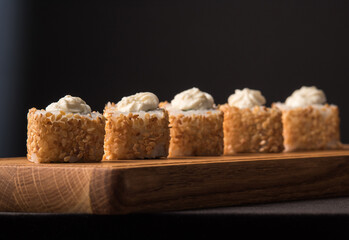 Sushi rolls with sesame seeds on a wooden sideboard. Japanese traditional cuisine concept.