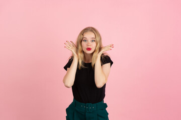 Surprising. Portrait of young emotional woman gesturing isolated on pink studio background. Human emotions, facial expression, sales, ad concept. Blonde caucasian pretty model gesturing. Copyspace.