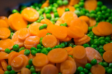 fast cooking peas with carrot slices in the pan