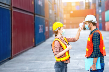 Industrial worker wear hygienic mask  and infrared thermometer at logistic warehouse container...