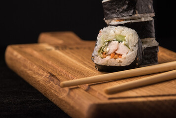 Sushi rolls on a wooden sideboard close-up. Japanese national cuisine concept.