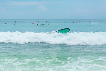 The guy is swimming on the surf board on the ocean. Healthy active lifestyle in summer vocation.