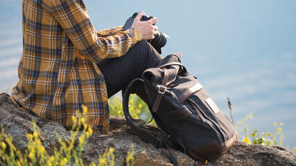 Traveller with backpack and camera on nature background