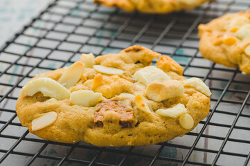 Freshly Baked Cookies- Smores White Chocolate Almonds on drying rack (focused)