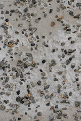 The texture of the old concrete wall. Rough concrete surface with many small pebbles. Great for background and design. Close-up.