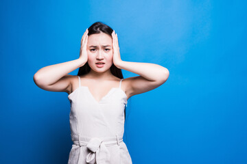 Young worried asian woman isolated on blue background