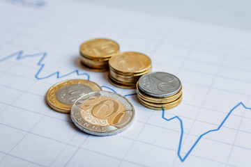 coins stacked in a row and in columns on the graph of the growth of finance