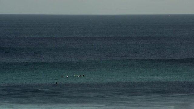 4k-24p. Amazing view. Surfers sit in the ocean
