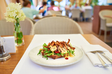 Bruschetta with roast beef and chanterelles on a  table.