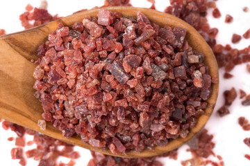 Closeup on black himalayan salt in a wooden spoon 