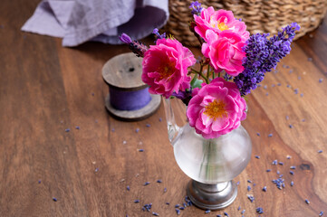 Small vintage glass vase with wild pink roses and purple lavender
