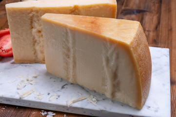Big wedges of parmigiano-reggiano parmesan hard Italian cheese made from cow milk or Grana Padano