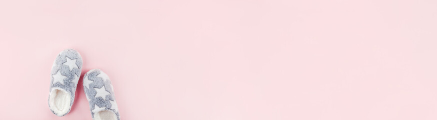 Soft fluffy slippers on pink background