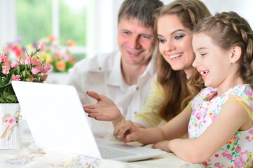 Girl with mother and father drawing at home