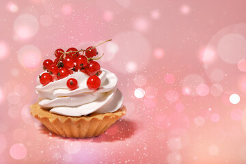cupcake with cream and currants on a pink background with bokeh